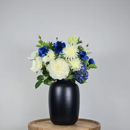 Luxe zijden boeket met witte en blauwe bloemen in zwarte vaas