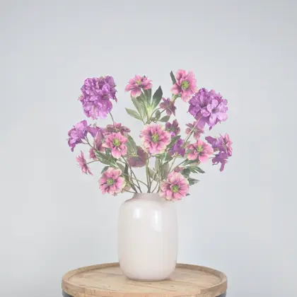 Zijden boeket met roze en paarse kunstbloemen met gouden accenten in witte vaas