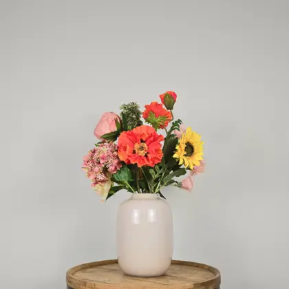 Zijden boeket met in gele, oranje en roze tinten met zonnebloem, oranje klaproos en roze hortensia in witte vaas
