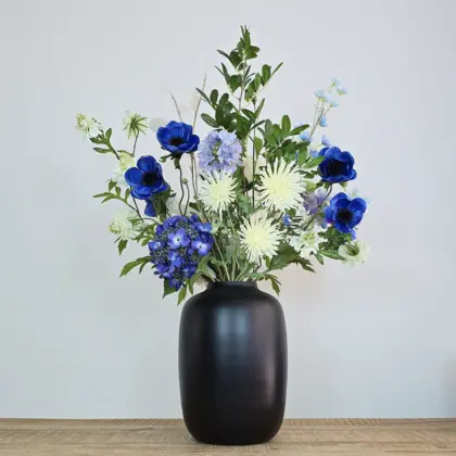 Luxe zijden boeket met witte en blauwe bloemen in zwarte vaas