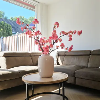 Zijden boeket in woonkamer met roze kunstbloesem