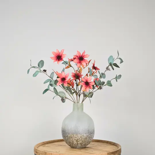 Zijden boeket in grijze vaas met groene eucalyptustakken en oranje-bruine dahlia bloemen