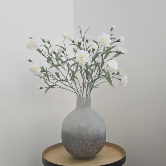 Wit kunstboeket met witte zijden bloemen in grijze vaas
