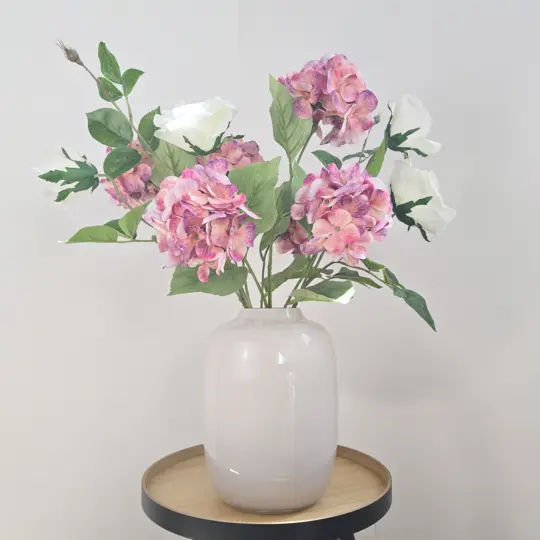 Zijden boeket met witte en roze kunstbloemen in witte vaas