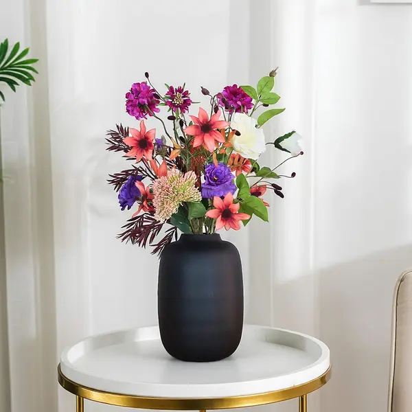 Zijden boeket met oranjebruine, paarse en roze kleuren in woonkamer