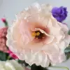 Lichtroze eustoma bloem in zijden kunstboeket met witte en paarse tinten