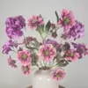 Kunstboeket met zijden bloemen in roze en paarse tinten met gouden accenten in witte vaas