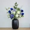 Luxe zijden boeket met witte en blauwe bloemen in zwarte vaas